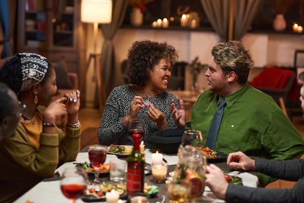 Grupo de amigos se divertindo sentado à mesa de jantar durante o jantar