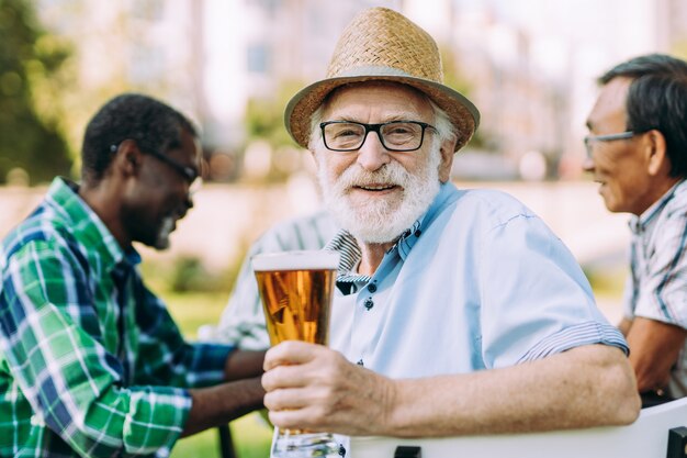 Grupo de amigos seniores bebendo uma cerveja no parque. Conceitos de estilo de vida sobre antiguidade e terceira idade