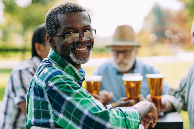 Grupo de amigos seniores bebendo uma cerveja no parque. Conceitos de estilo de vida sobre antiguidade e terceira idade