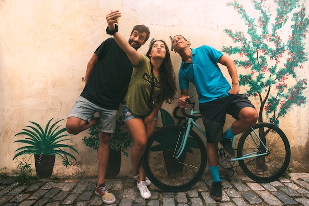 Foto grupo de amigos tira uma selfie com o celular na rua copyspace estilo de vida