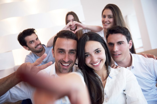 grupo de amigos tirando foto de selfie com tablet em casa moderna dentro de casa