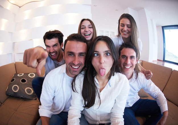 grupo de amigos tirando foto de selfie com tablet em casa moderna dentro de casa