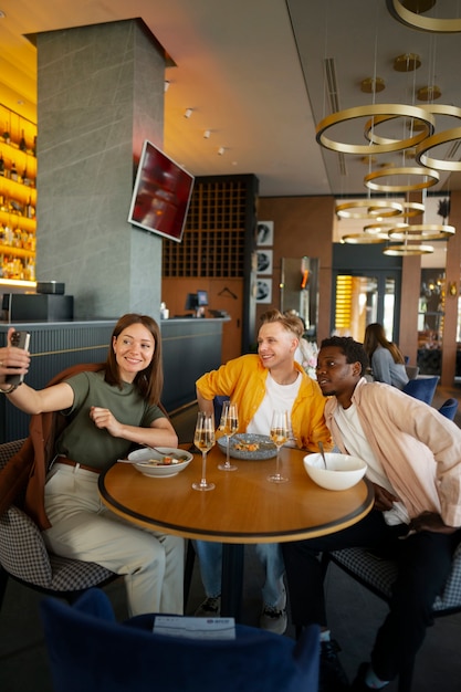 Foto grupo de amigos tirando selfie em um restaurante