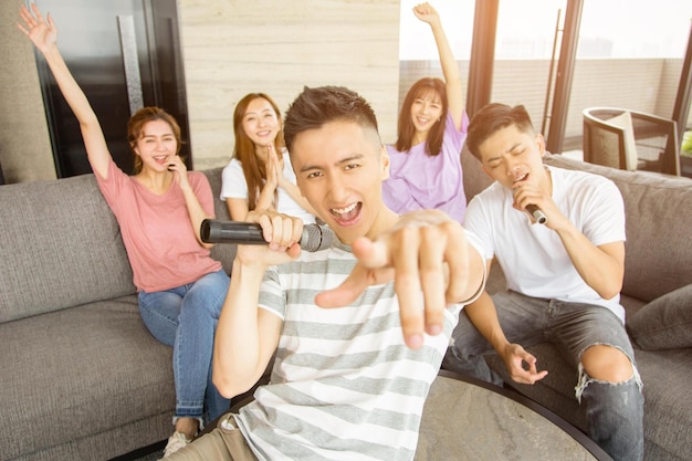 Grupo de amigos tocando karaokê em casa