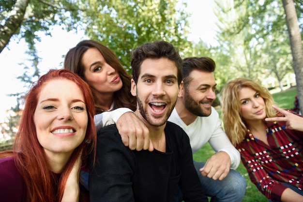 Grupo de amigos tomando selfie em fundo urbano