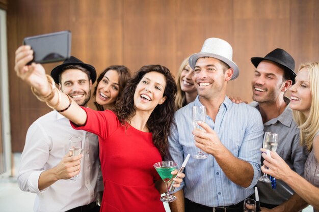 Foto grupo de amigos tomando selfie na festa