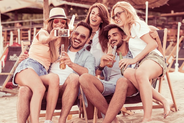 Grupo de amigos tomando selfie na praia