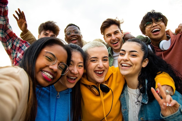 Grupo de amigos universitários adolescentes multirraciais se divertindo ao ar livre Pessoas felizes tomando selfie