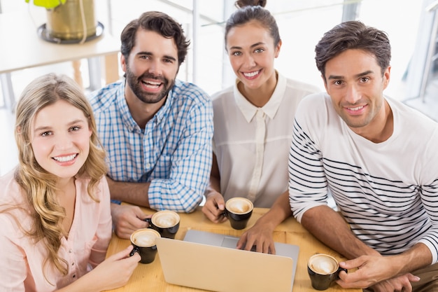 Grupo de amigos usando laptop enquanto tomar café