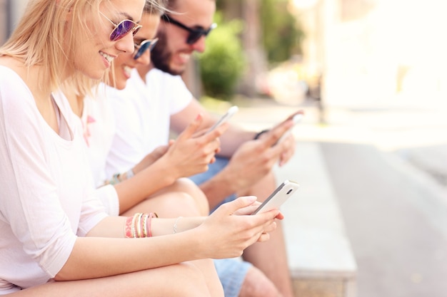 grupo de amigos usando smartphones na cidade