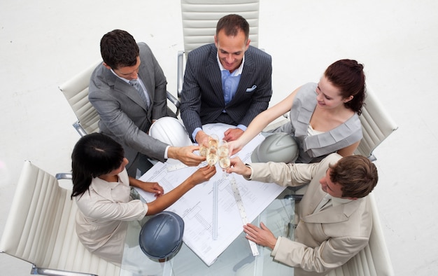 Grupo de arquitetos brindando com champanhe no escritório