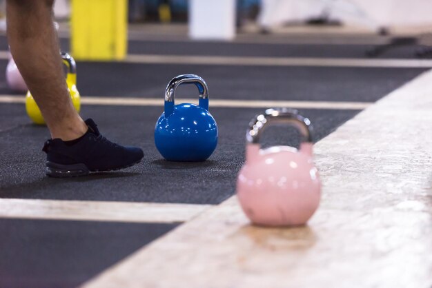 grupo de atletas jovens saudáveis, fazendo exercícios com kettlebells no cross fitness studio