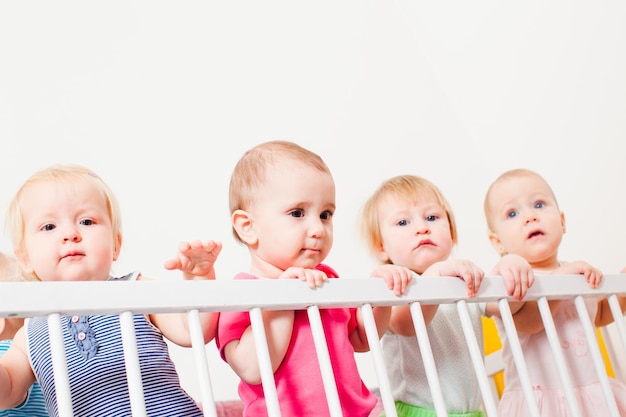 Grupo de bebês em pé no berço, creche