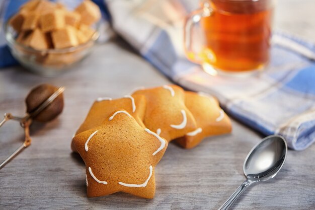 Grupo de biscoitos de gengibre em forma de estrela recém-assados na mesa de madeira. Foco seletivo, conceito de hora do chá de aquecimento no inverno congelado.