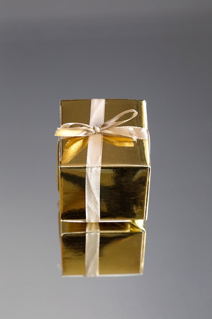 Grupo de caixas de presente espumante ouro sobre fundo cinzento com reflexão