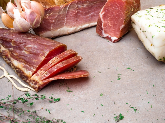 Grupo de carne seca salgada de presunto defumado com um pouco de alho e ervas