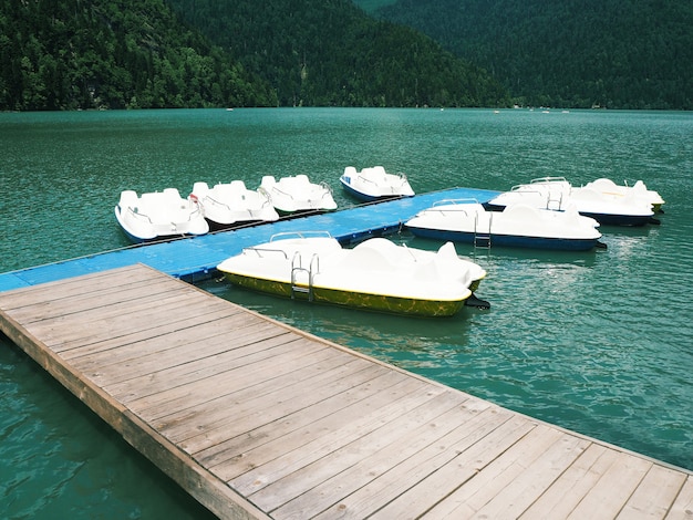 Grupo de catamarãs brancos ancorados no fundo do lago azul. pedalinhos aquáticos