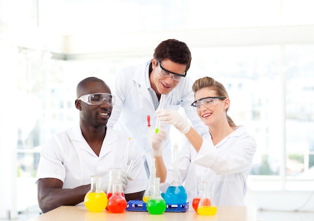 Grupo de cientistas que examina tubos de ensaio