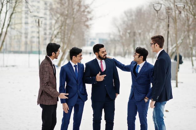 Grupo de cinco empresário indiano de terno posou ao ar livre e conduzir uma discussão em dia de inverno na Europa.