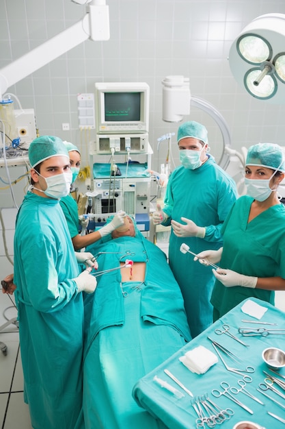 Grupo de cirurgiões que operam um paciente em um cirurgião