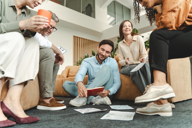 Grupo de colegas de negócios sorridentes conversando planejando inicialização trabalhando em escritório moderno