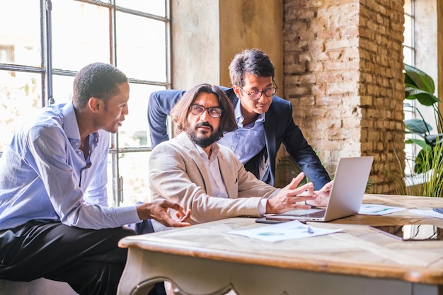 Grupo de colegas de trabalho resolvendo juntos na frente do computador e gerando novos projetos