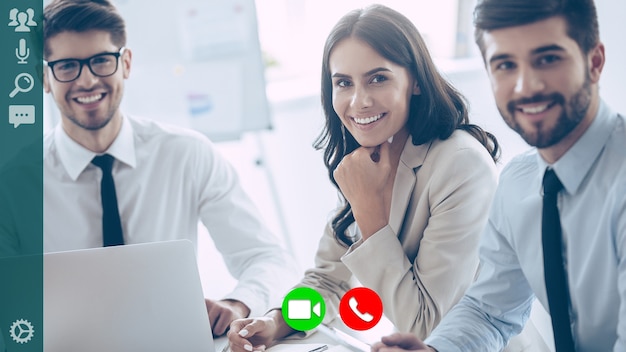 Grupo de colegas de trabalho sorrindo e se comunicando durante a videoconferência