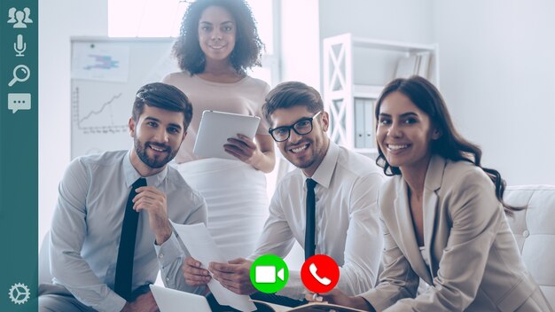 Grupo de colegas sorrindo e olhando para a câmera durante a videoconferência