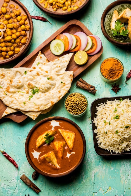 Grupo de comida indiana como Palak Paneer Butter Masala, Choley ou chola e curry de feijão preto com Naan e arroz