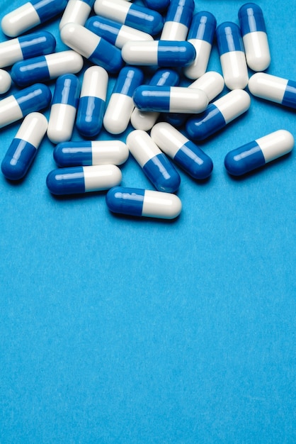 grupo de comprimidos ou cápsulas em fundo azul