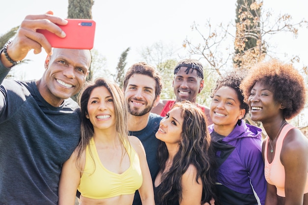 Grupo de corredores tirando uma selfie em um parque. Feliz e sorridente. Enquadramento horizontal.