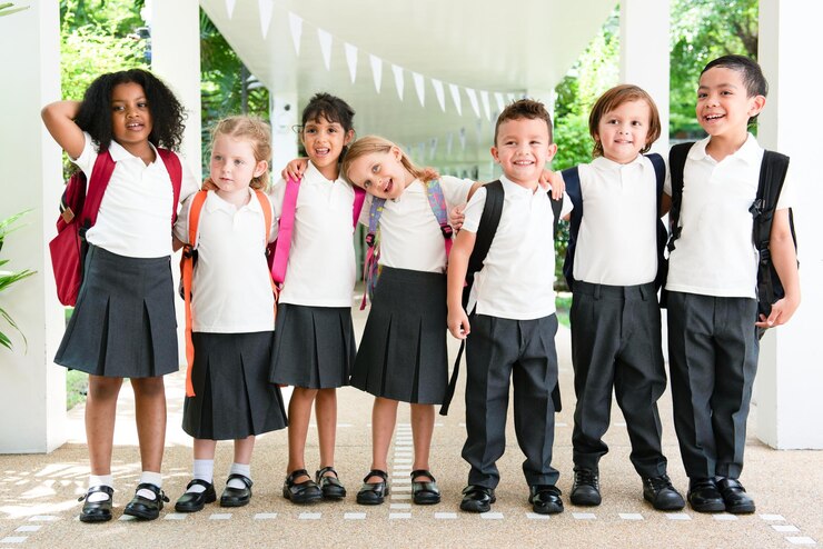 Foto grupo de crianças diversas em uniformes escolares com mochilas sorrindo e de pé juntos crianças felizes uniformes de escola mochilas grupo diversificado crianças sorrindo crianças escolares lindas e diversificadas