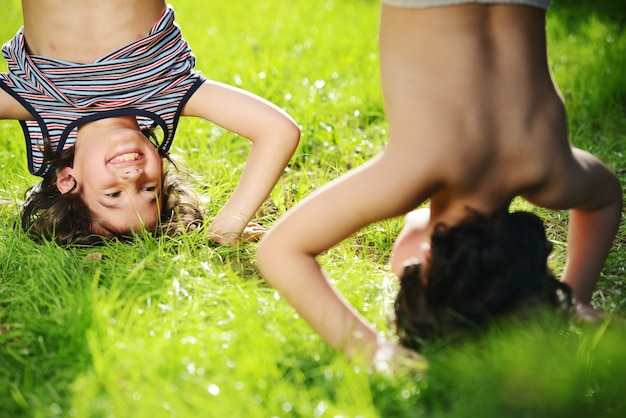 Grupo de crianças felizes brincando ao ar livre no parque da primavera