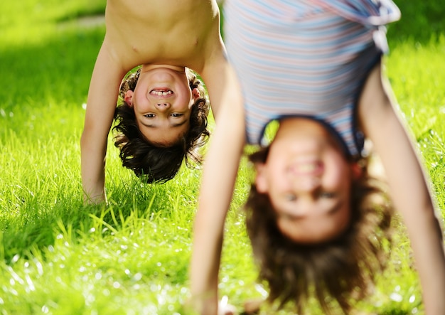 Grupo de crianças felizes brincando ao ar livre no parque da primavera