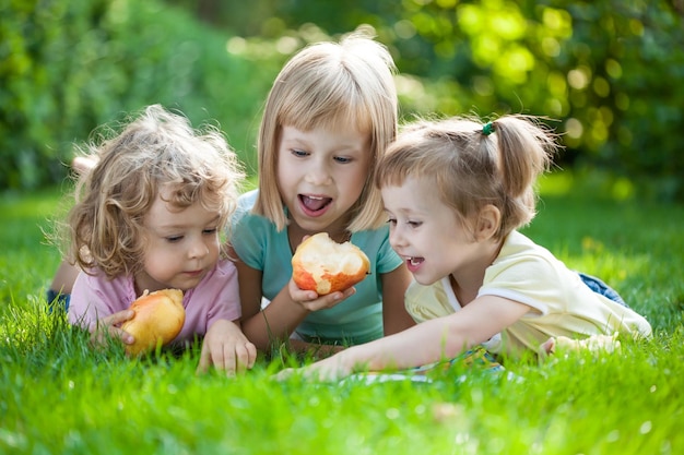 Grupo de crianças felizes brincando ao ar livre no parque primavera