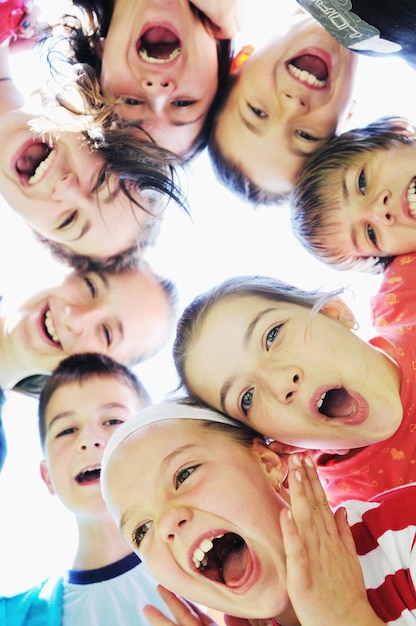 Foto grupo de crianças felizes sorrindo juntos e mantendo as cabeças muito próximas