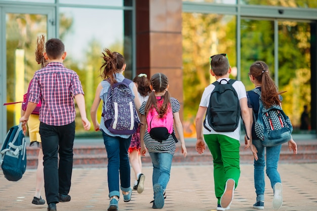 Grupo de crianças indo para a escola juntos.