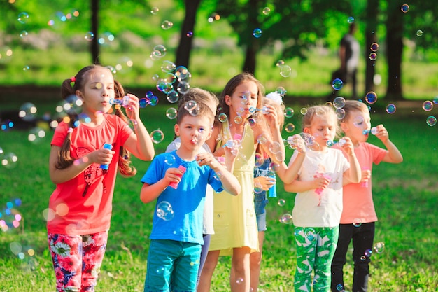 Grupo de crianças soprando bolhas de sabão