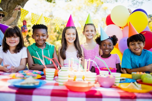 Grupo de crianças sorrindo e posando durante uma festa de aniversário