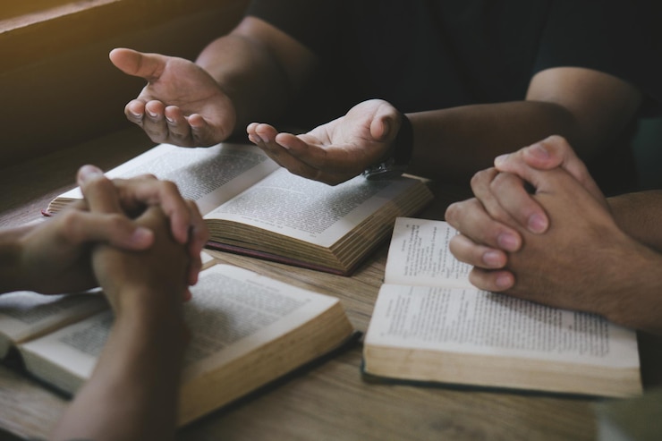 Foto grupo de cristãos lendo e estudando a bíblia em casa e orando juntos
