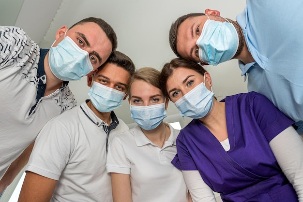 Foto grupo de dentistas segurando instrumentos médicos e parados em círculo em uma reunião hospital de pacientes