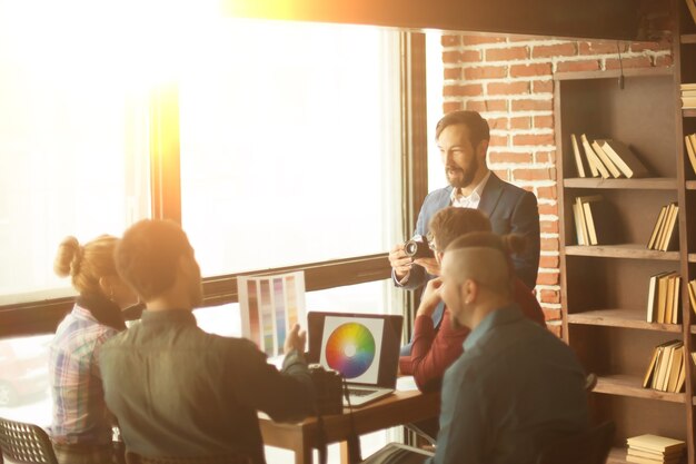 Grupo de designers criativos discutindo uma nova paleta de cores no local de trabalho em um escritório moderno