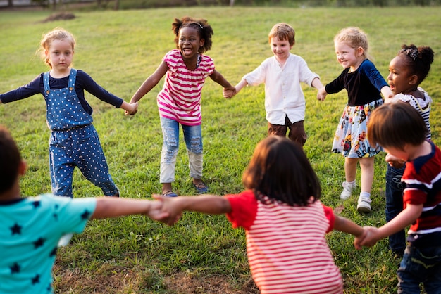 Foto grupo de diversas crianças jogando no campo juntos