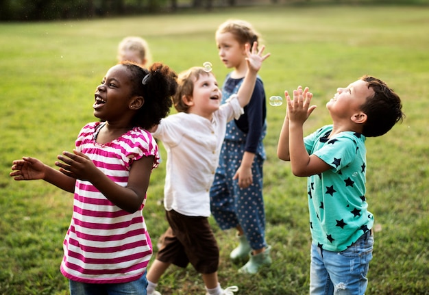 Foto grupo de diversas crianças jogando no campo juntos