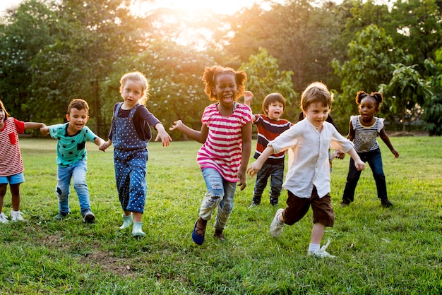 Foto grupo de diversas crianças jogando no campo juntos