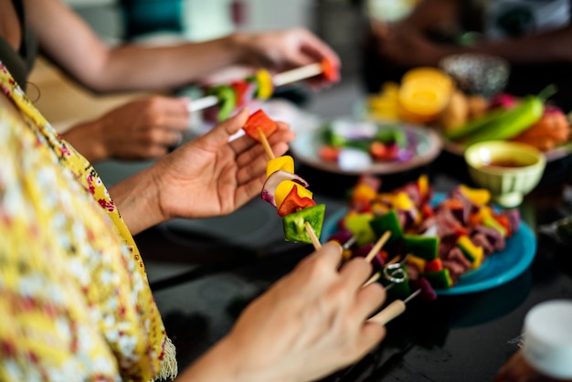 Foto grupo de diversos amigos preparando churrasco na cozinha juntos