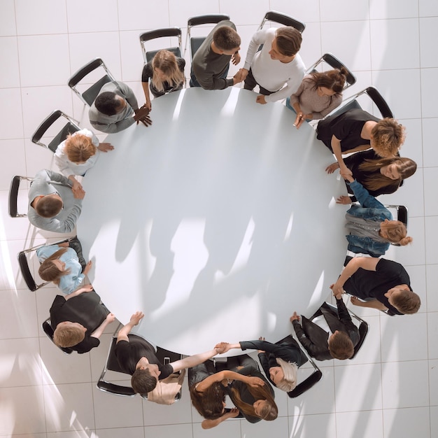 Foto grupo de diversos jovens em uma mesa redonda