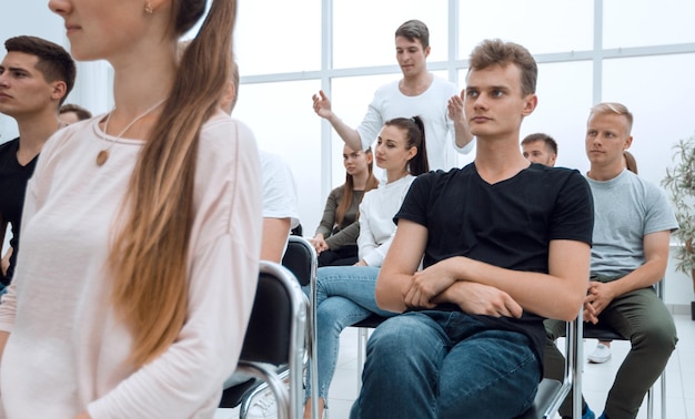 Grupo de diversos jovens sentados em uma sala de conferências