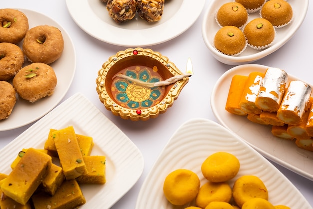 Grupo de doces indianos variados ou mithai com diya