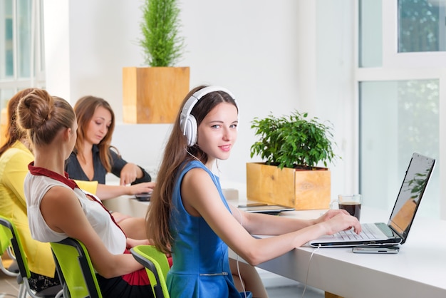 Grupo de empresária bonita trabalhando em conjunto com o novo projeto de inicialização usando o laptop no apartamento moderno